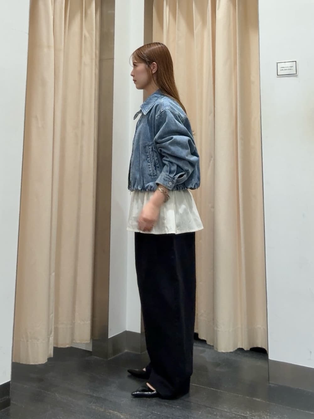 ブルー系のデニムジャケット、ホワイト系のシャツ/ブラウス、ブラック系のその他パンツを着用したレディースの秋コーディネートの2枚目の写真