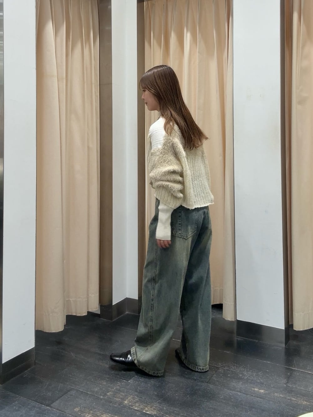 ホワイト系のニット/セーター、ホワイト系のカーディガン/ボレロ、ブルー系のデニムパンツを着用したレディースの秋コーディネートの2枚目の写真