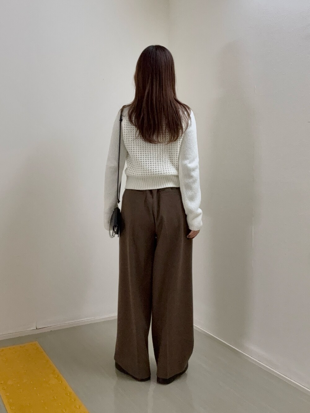 ホワイト系のニット/セーター、ブラウン系のその他パンツ、ブラック系の財布を着用したレディースの冬コーディネートの3枚目の写真