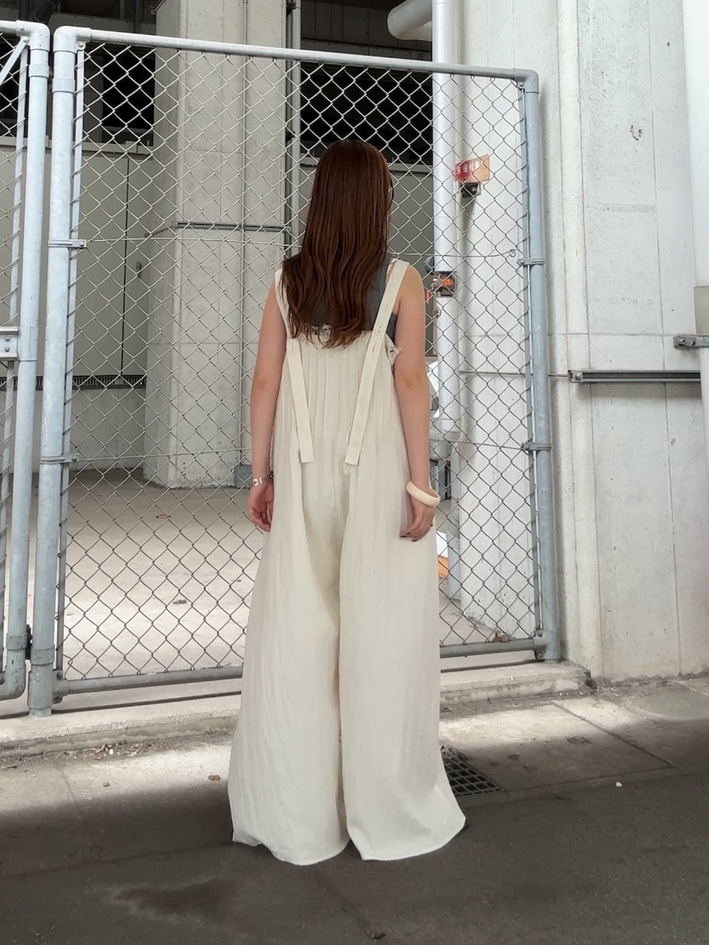 グレー系のタンクトップ、ホワイト系のその他パンツ、レッド系のネックレスを着用したレディースの夏コーディネートの3枚目の写真