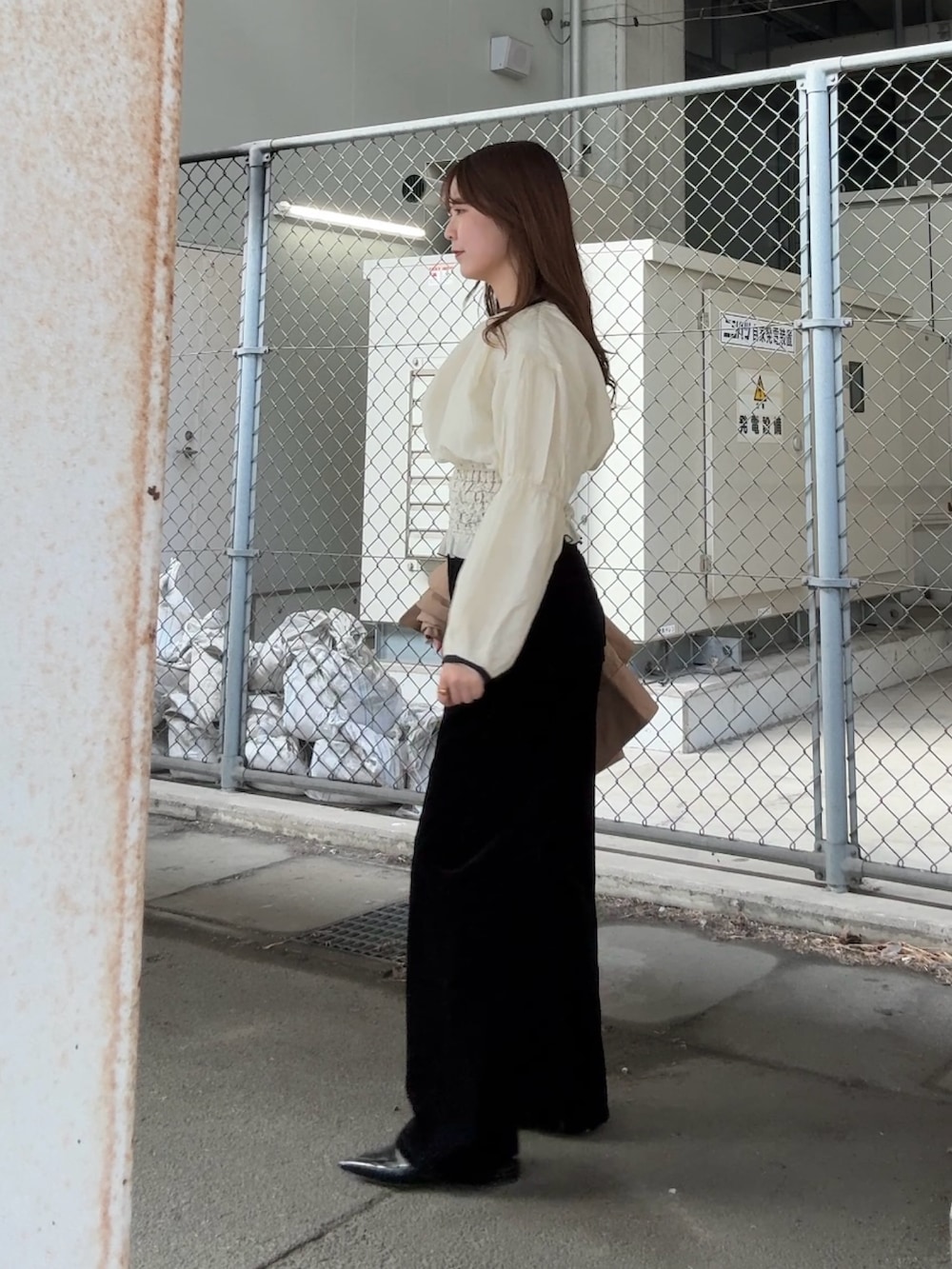 ベージュ系のステンカラーコート、ホワイト系のシャツ/ブラウス、ブラック系のデニムパンツを着用したレディースの冬コーディネートの3枚目の写真