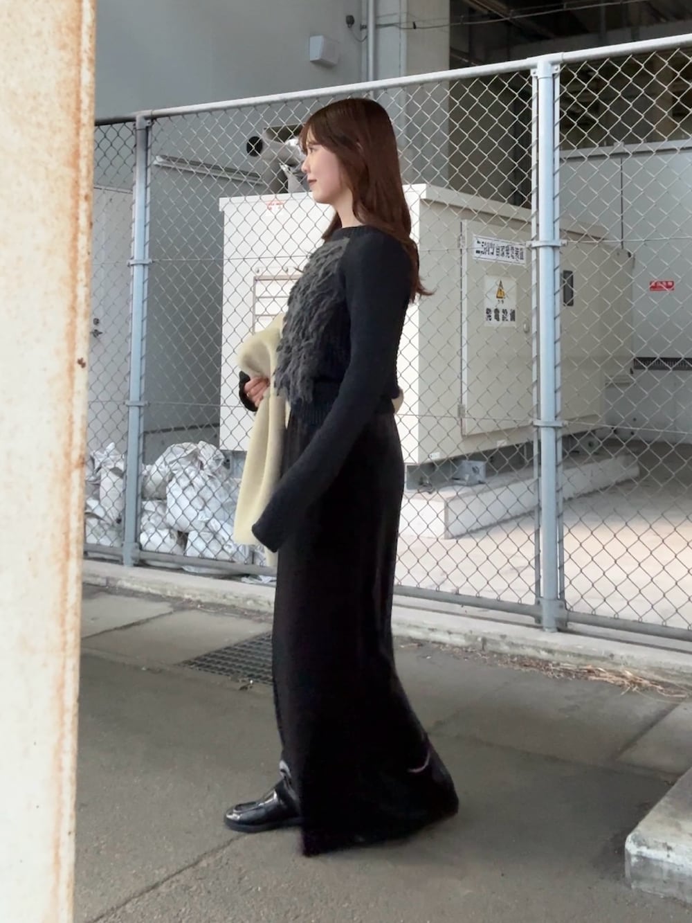 グレー系のニット/セーター、グレー系のスカート、ベージュ系のその他アウターを着用したレディースの冬コーディネートの3枚目の写真