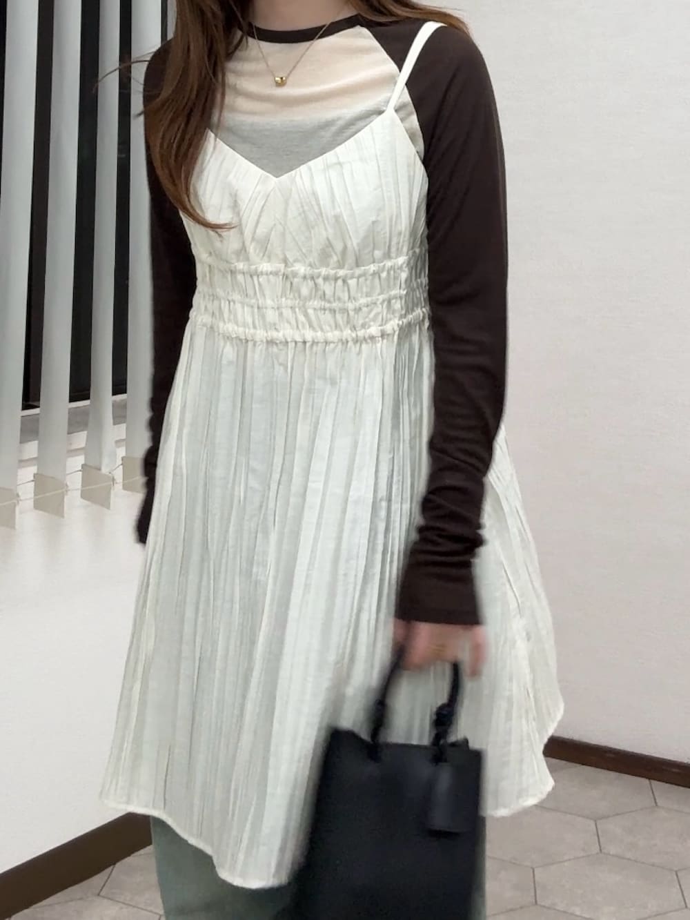 ホワイト系のワンピース、ベージュ系のTシャツ/カットソー、ブルー系のデニムパンツを着用したレディースの春コーディネートの4枚目の写真