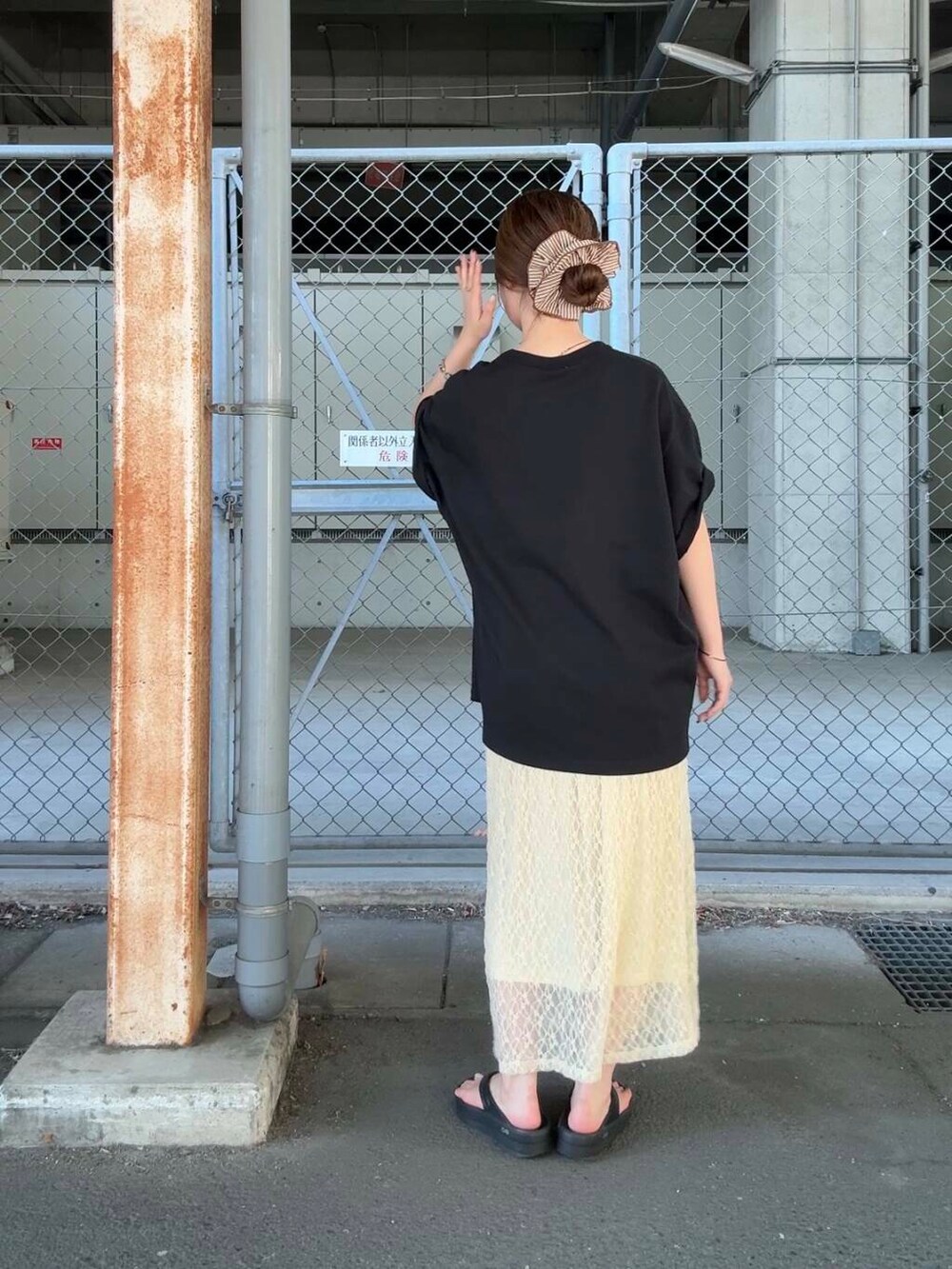 ブラック系のTシャツ/カットソー、ホワイト系のスカート、ブラウン系のヘアゴムを着用したレディースの夏コーディネートの3枚目の写真