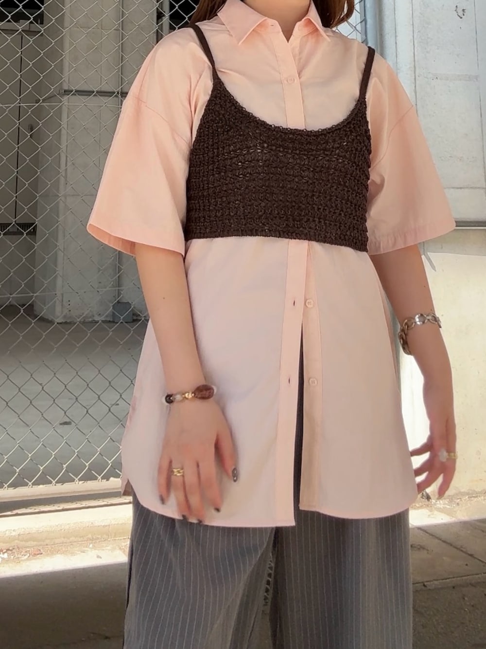 ピンク系のシャツ/ブラウス、グレー系のその他パンツ、ブラウン系のヘアゴムを着用したレディースの夏コーディネートの4枚目の写真
