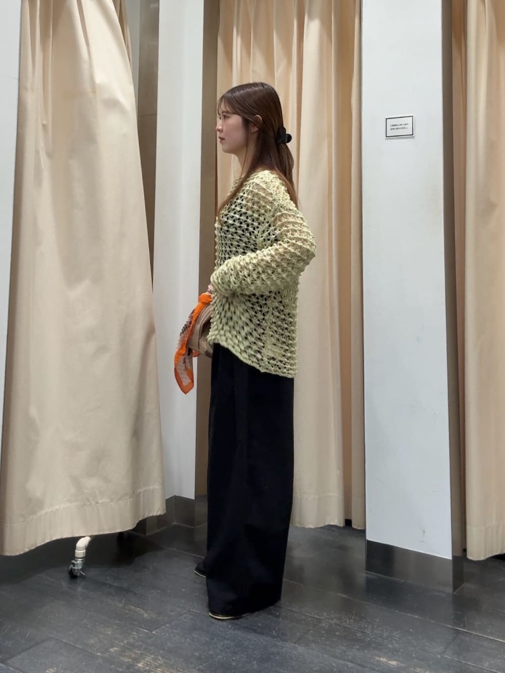 グリーン系のニット/セーター、ブラック系のその他パンツ、ベージュ系のボストンバッグを着用したレディースの春コーディネートの2枚目の写真