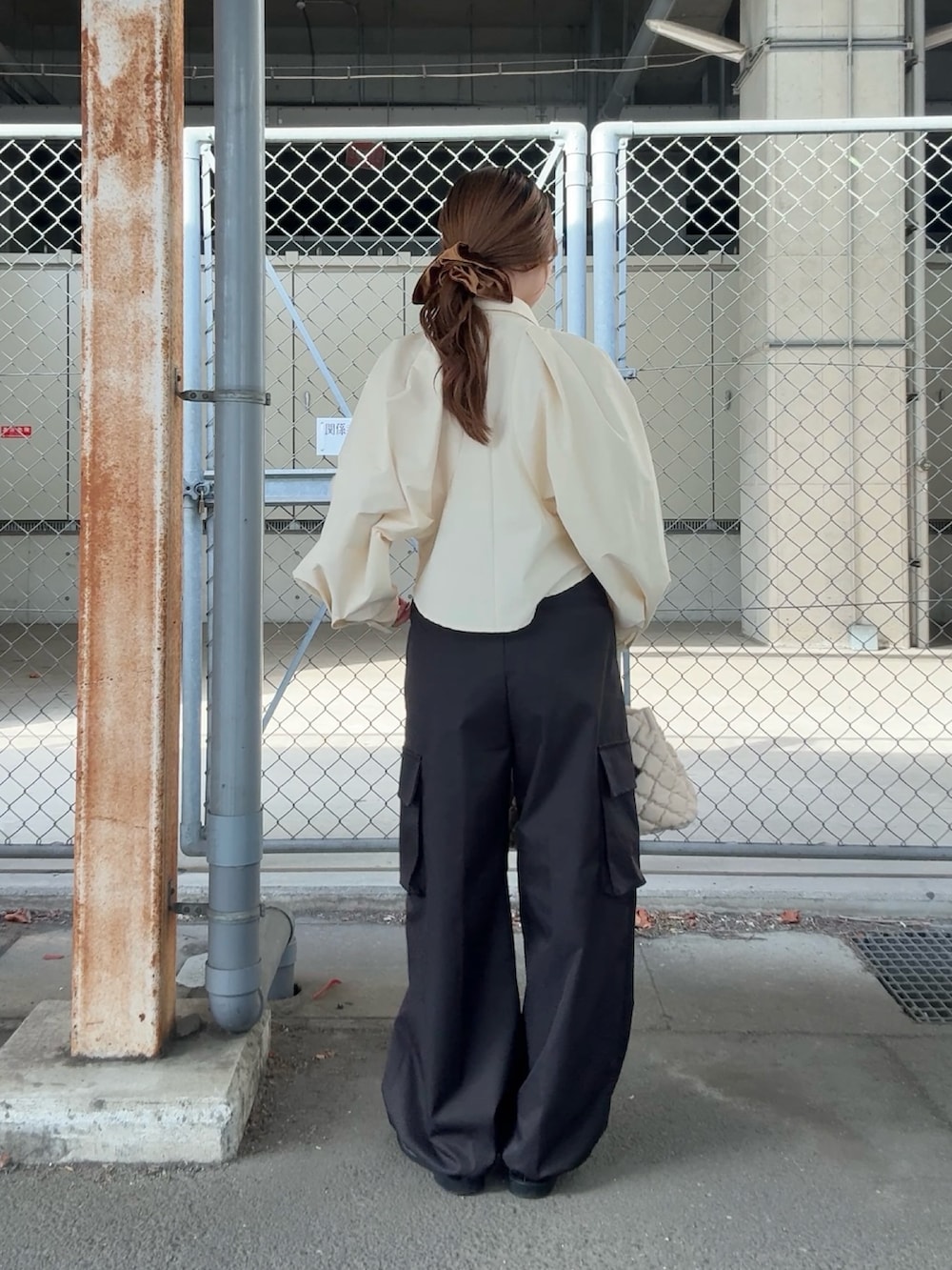 ベージュ系のシャツ/ブラウス、ブラック系のその他パンツ、ホワイト系のハンドバッグを着用したレディースの秋コーディネートの3枚目の写真
