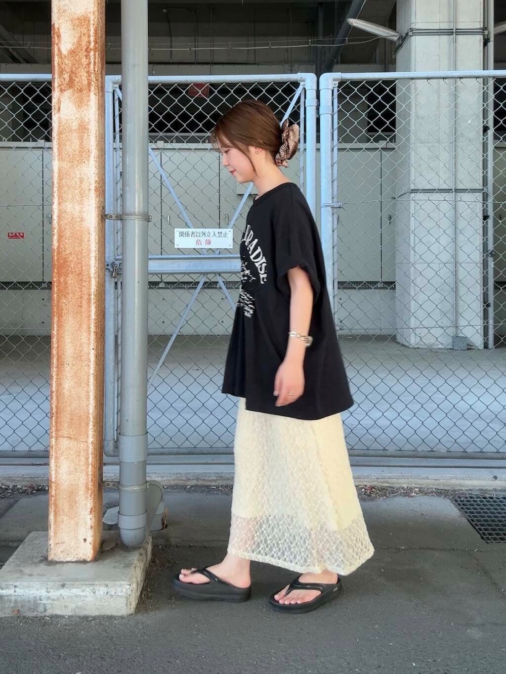 ブラック系のTシャツ/カットソー、ホワイト系のスカート、ブラウン系のヘアゴムを着用したレディースの夏コーディネートの2枚目の写真