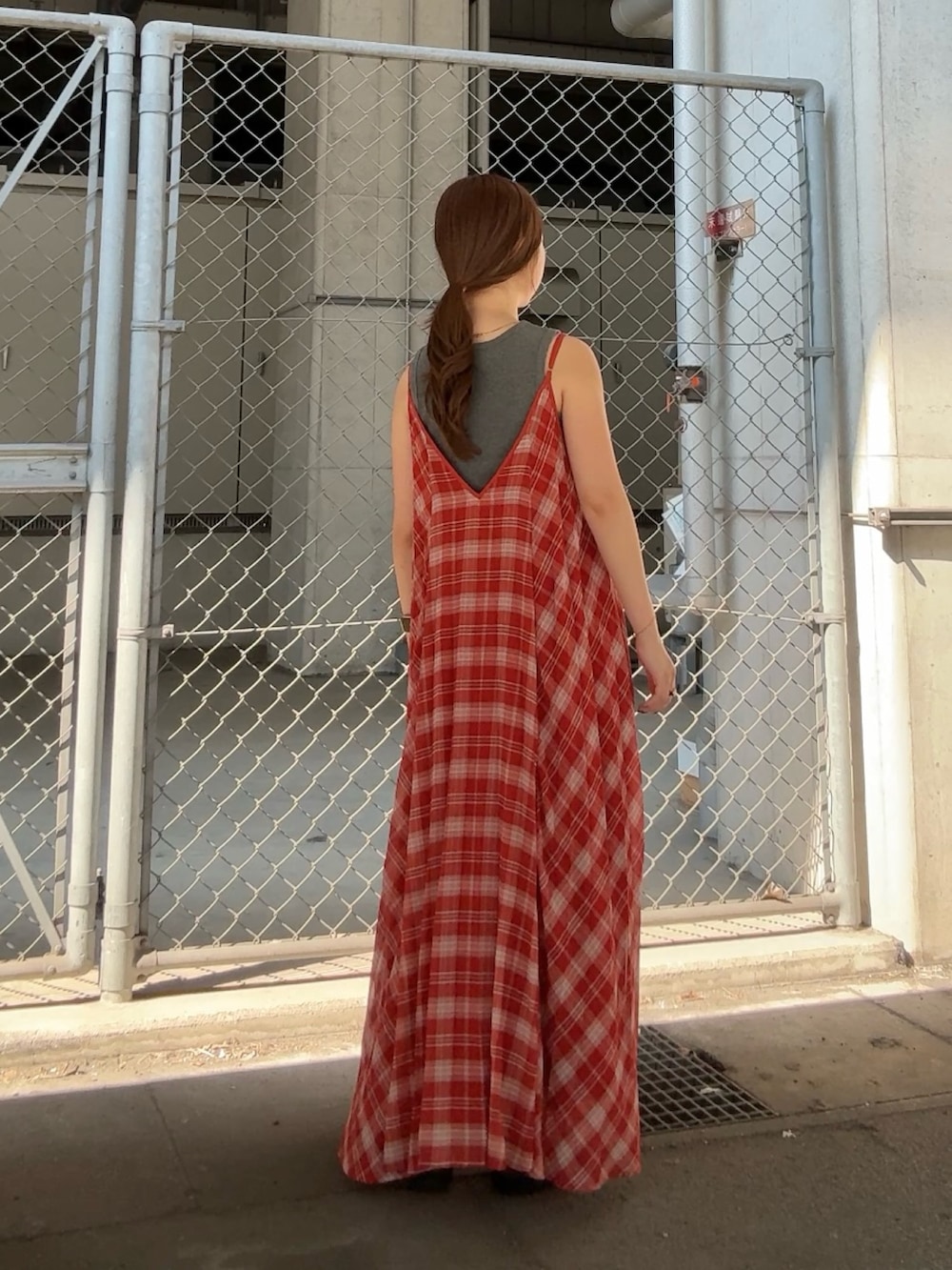 グレー系のタンクトップ、レッド系のワンピースを着用したレディースの夏コーディネートの3枚目の写真