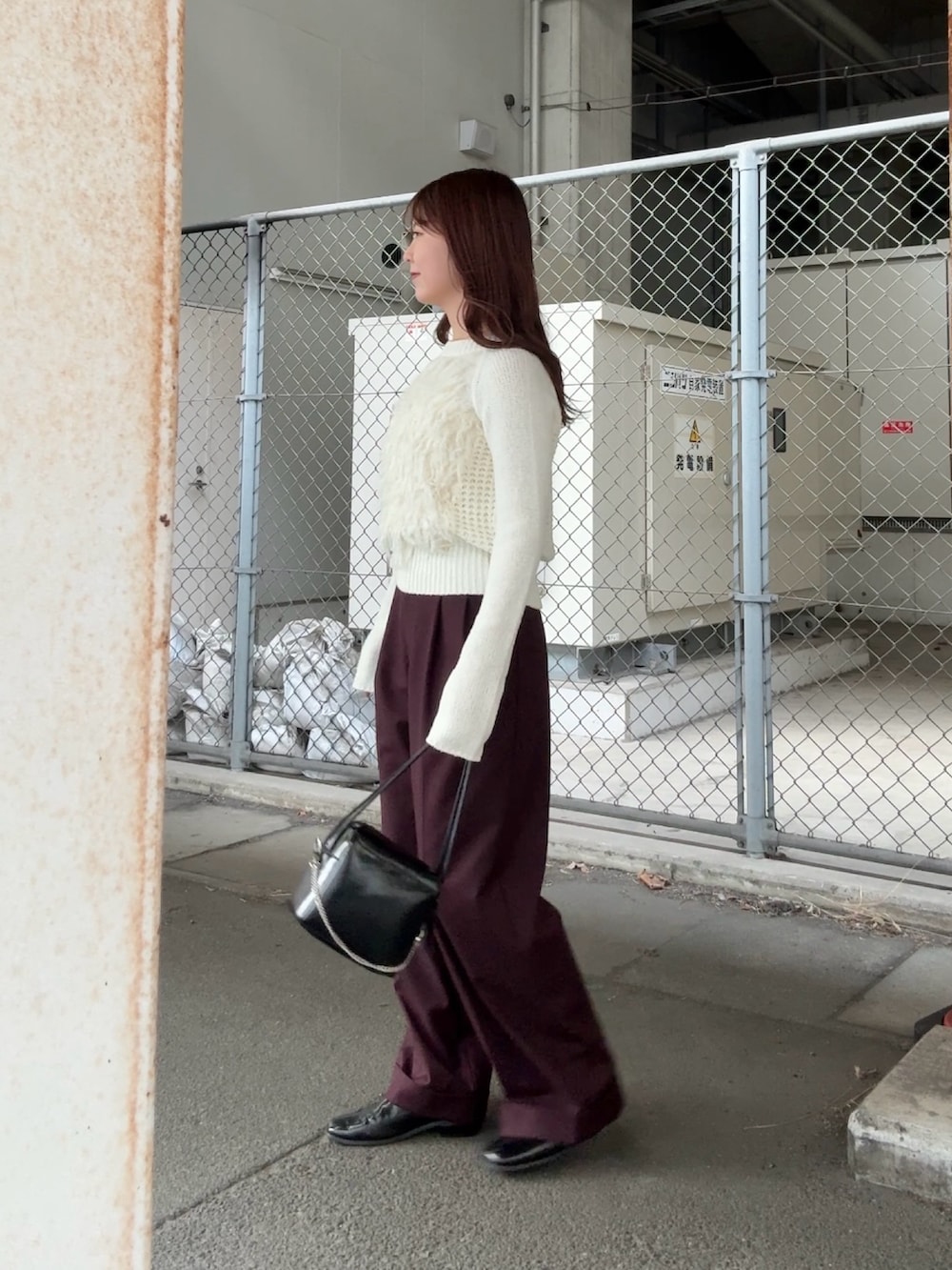 ホワイト系のニット/セーター、ブラック系のショルダーバッグ、レッド系のその他パンツを着用したレディースの冬コーディネートの2枚目の写真