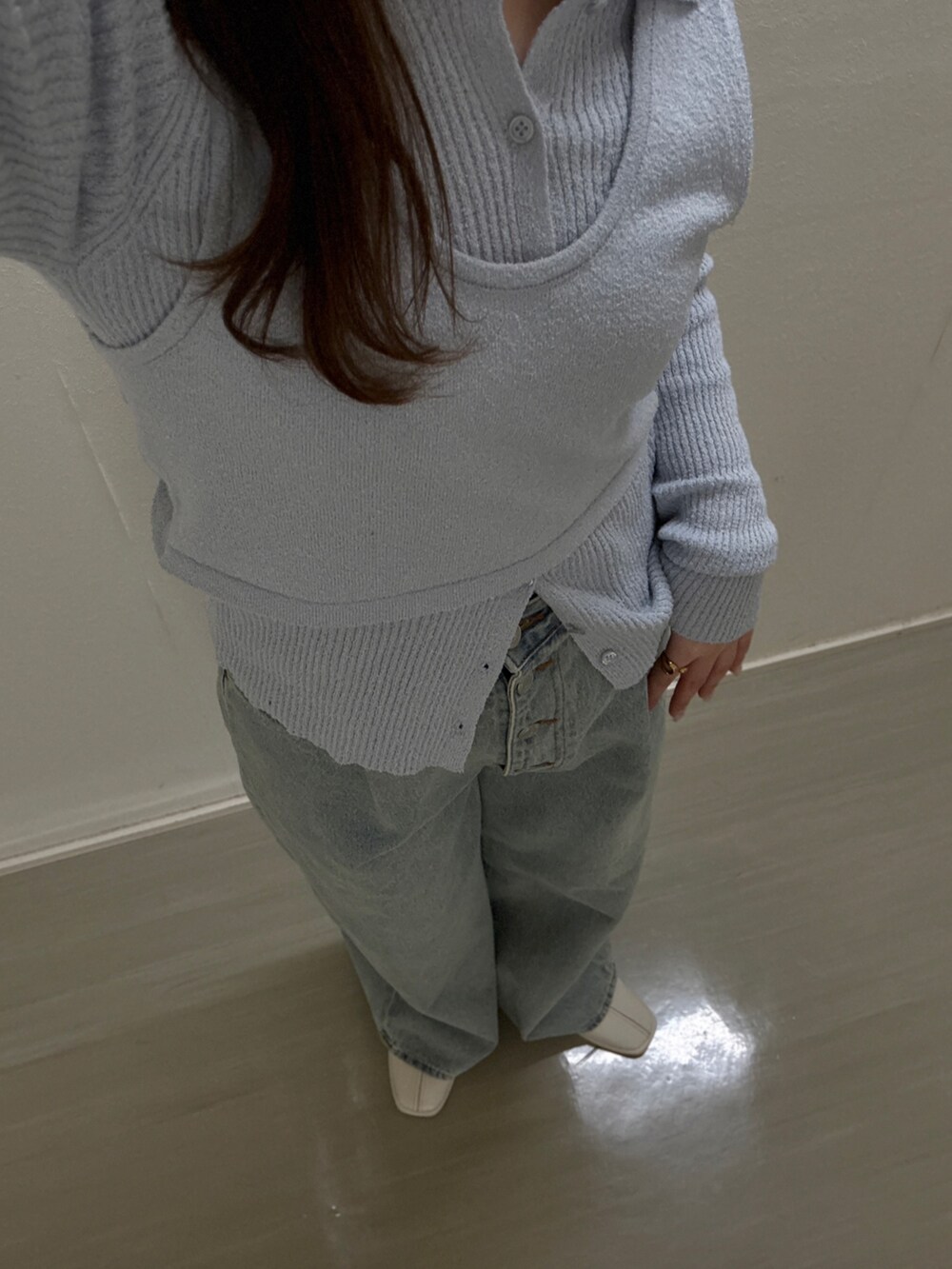 ブルー系のニット/セーター、ブルー系のデニムパンツ、ホワイト系のパンプスを着用したレディースの冬コーディネートの4枚目の写真