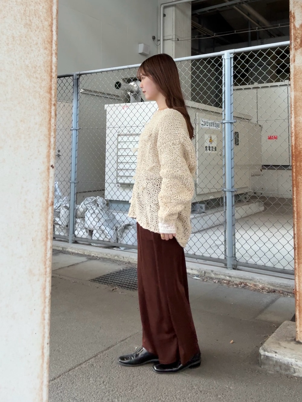 ホワイト系のニット/セーター、ホワイト系のTシャツ/カットソー、ブラウン系のスカートを着用したレディースの冬コーディネートの2枚目の写真