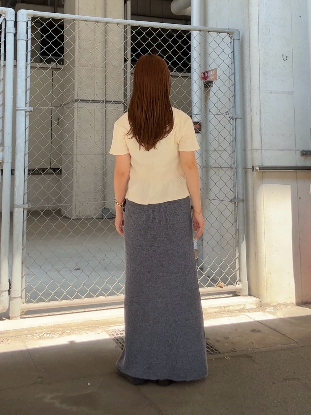 ホワイト系のTシャツ/カットソー、ブルー系のスカート、ブラウン系のネックレスを着用したレディースの夏コーディネートの3枚目の写真