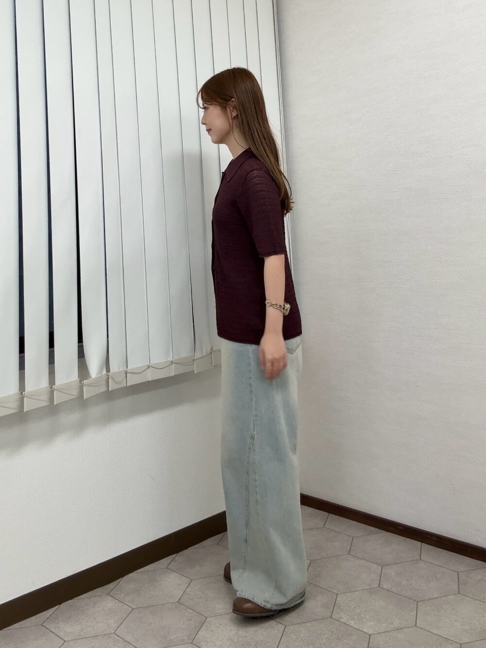 レッド系のニット/セーター、ブルー系のデニムパンツ、ブラウン系のサンダルを着用したレディースの夏コーディネートの2枚目の写真
