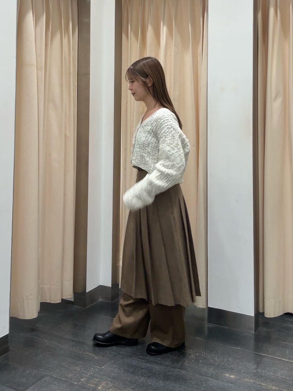 ホワイト系のニット/セーター、ブラウン系のスカート、ブラウン系のその他パンツを着用したレディースの秋コーディネートの2枚目の写真