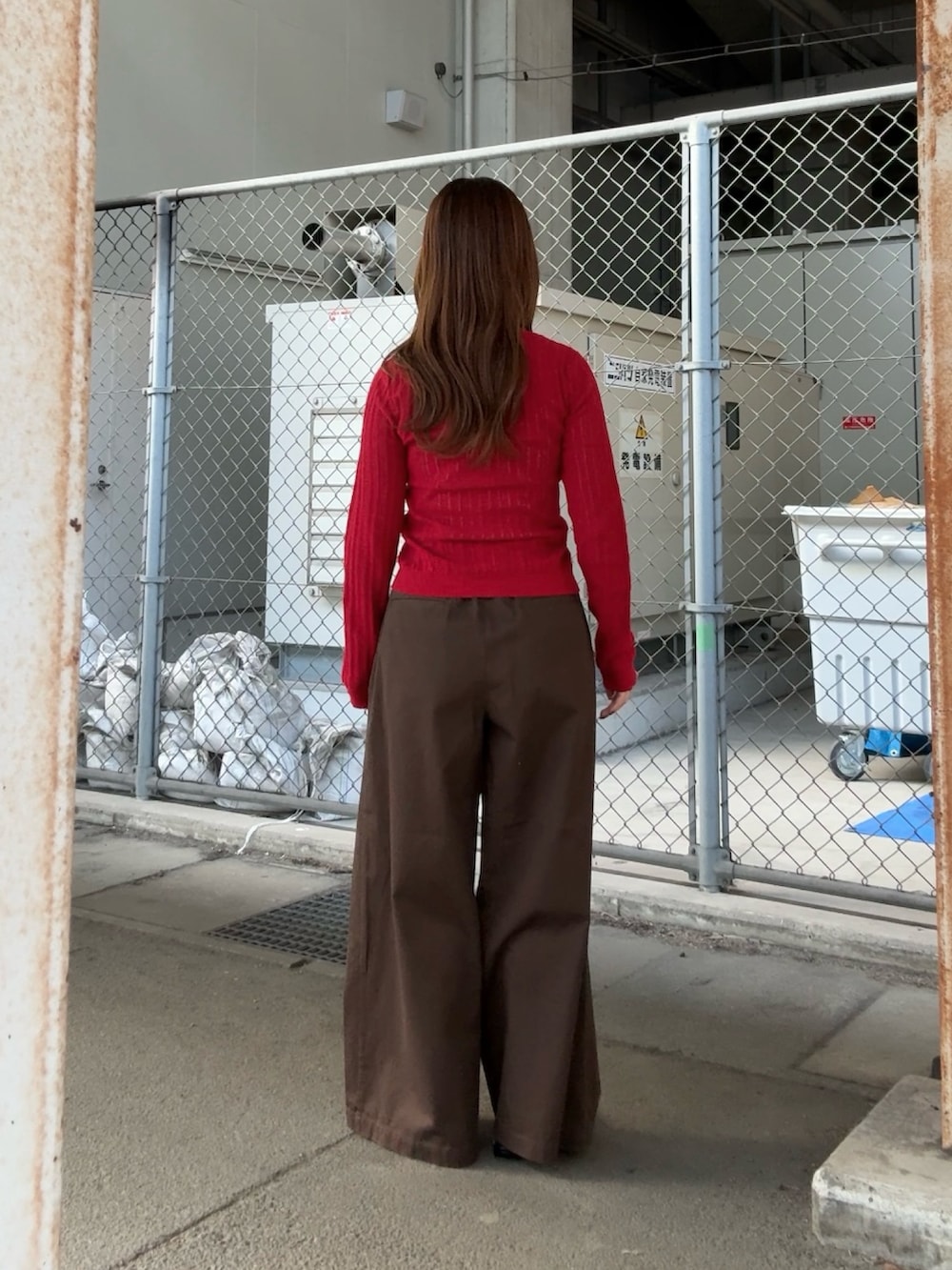 ブラウン系のその他パンツ、レッド系のニット/セーター、ブラウン系のメガネを着用したレディースの春コーディネートの3枚目の写真