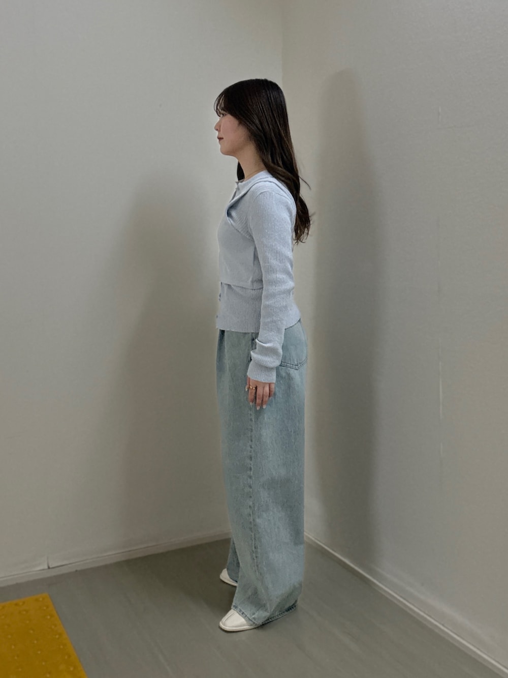 ブルー系のニット/セーター、ブルー系のデニムパンツ、ホワイト系のパンプスを着用したレディースの冬コーディネートの2枚目の写真