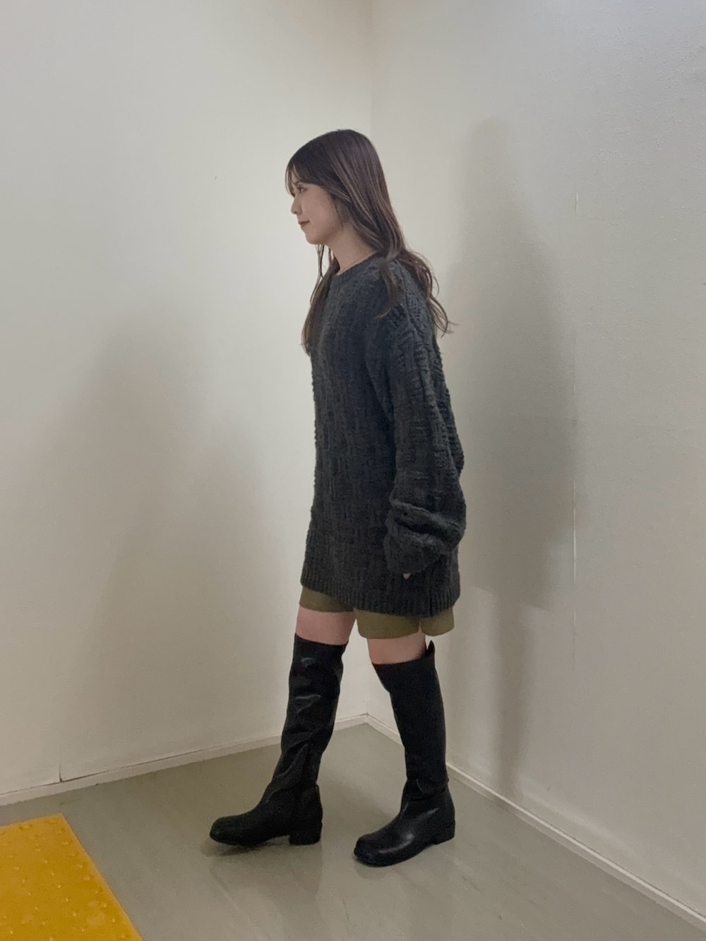 グレー系のニット/セーター、グリーン系のその他パンツ、ブラック系のブーツを着用したレディースの秋コーディネートの2枚目の写真