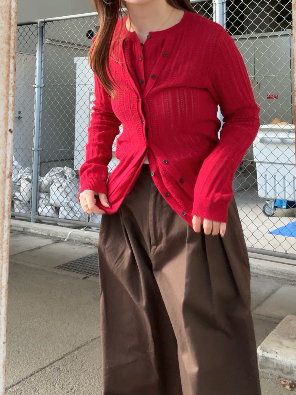 ブラウン系のその他パンツ、レッド系のニット/セーター、ブラウン系のメガネを着用したレディースの春コーディネートの4枚目の写真