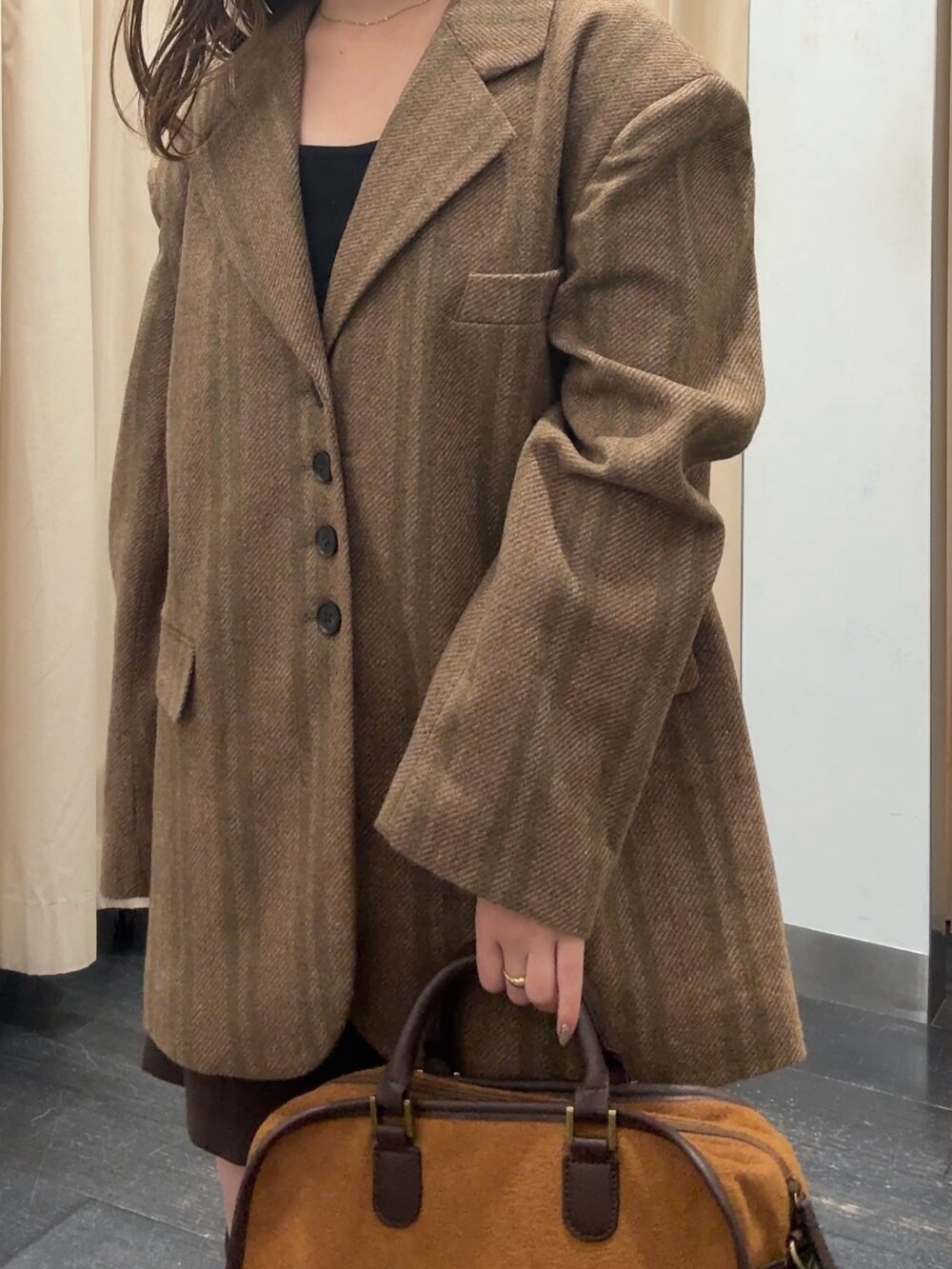 オレンジ系のその他アウター、ブラウン系のその他パンツ、イエロー系のボストンバッグを着用したレディースの秋コーディネートの4枚目の写真