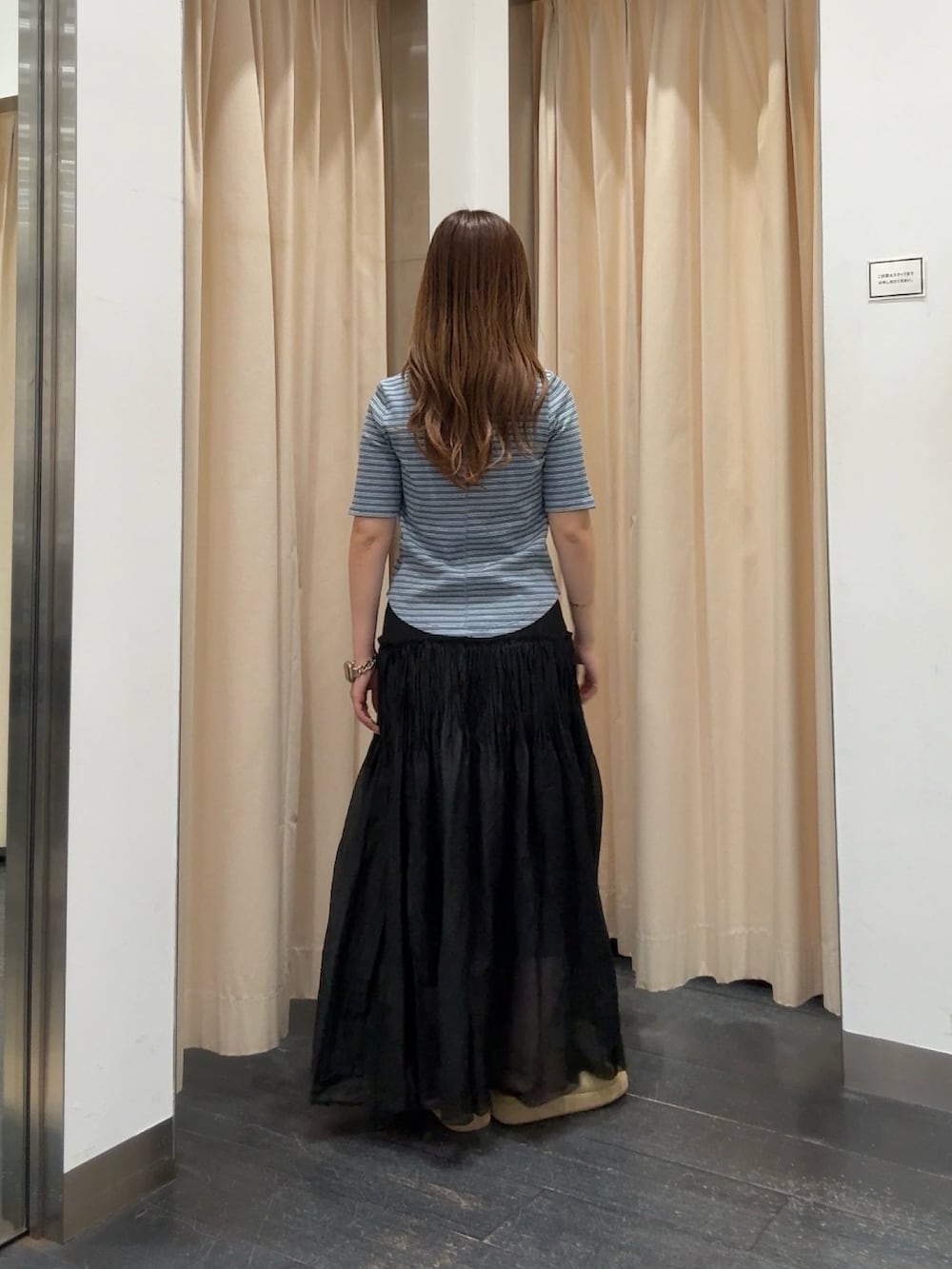ブルー系のTシャツ/カットソー、ブラック系のスカート、ベージュ系のサンダルを着用したレディースの夏コーディネートの3枚目の写真