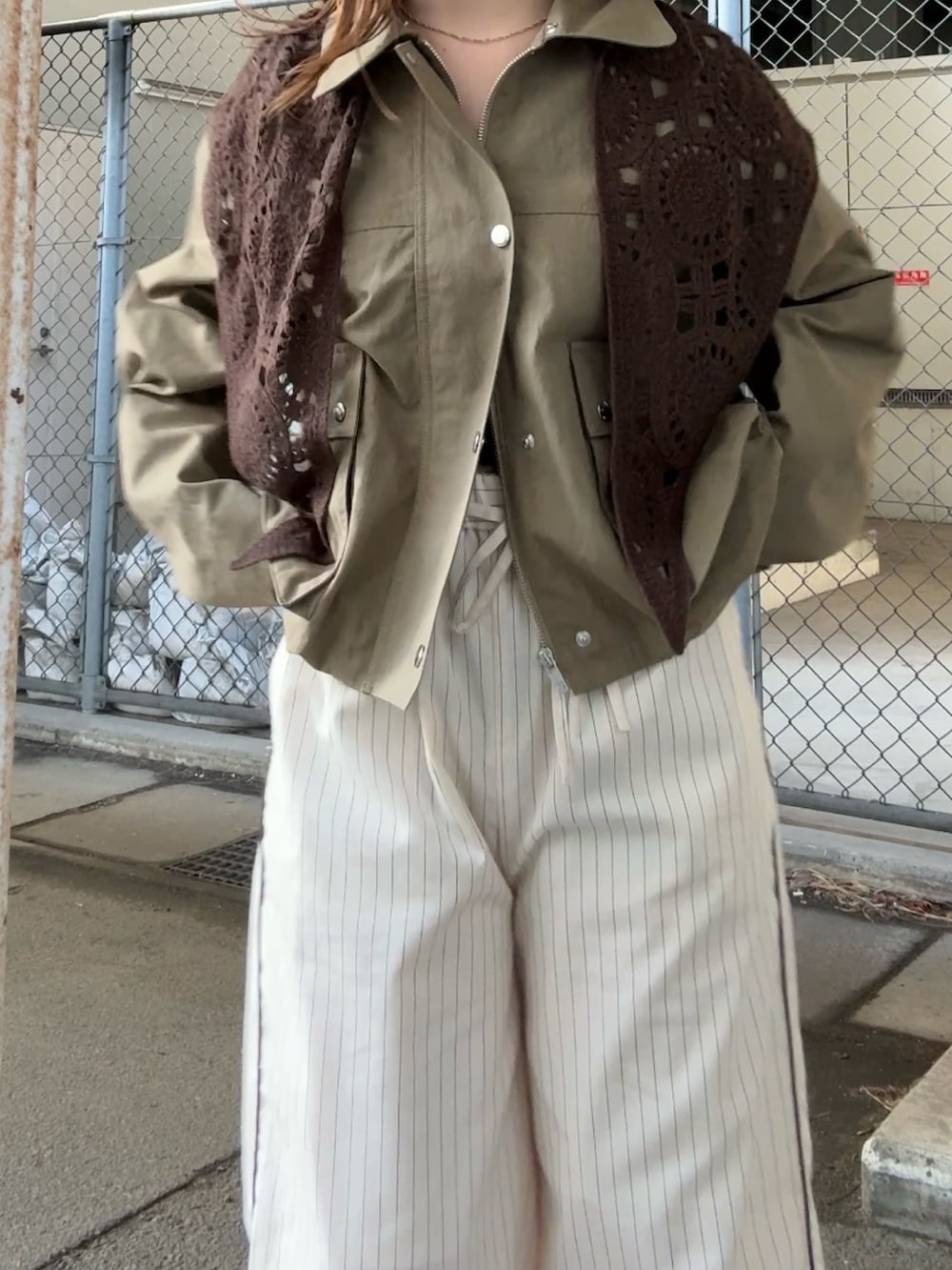 グリーン系のブルゾン、ホワイト系のその他パンツ、ブラウン系のバンダナ/スカーフを着用したレディースの冬コーディネートの4枚目の写真