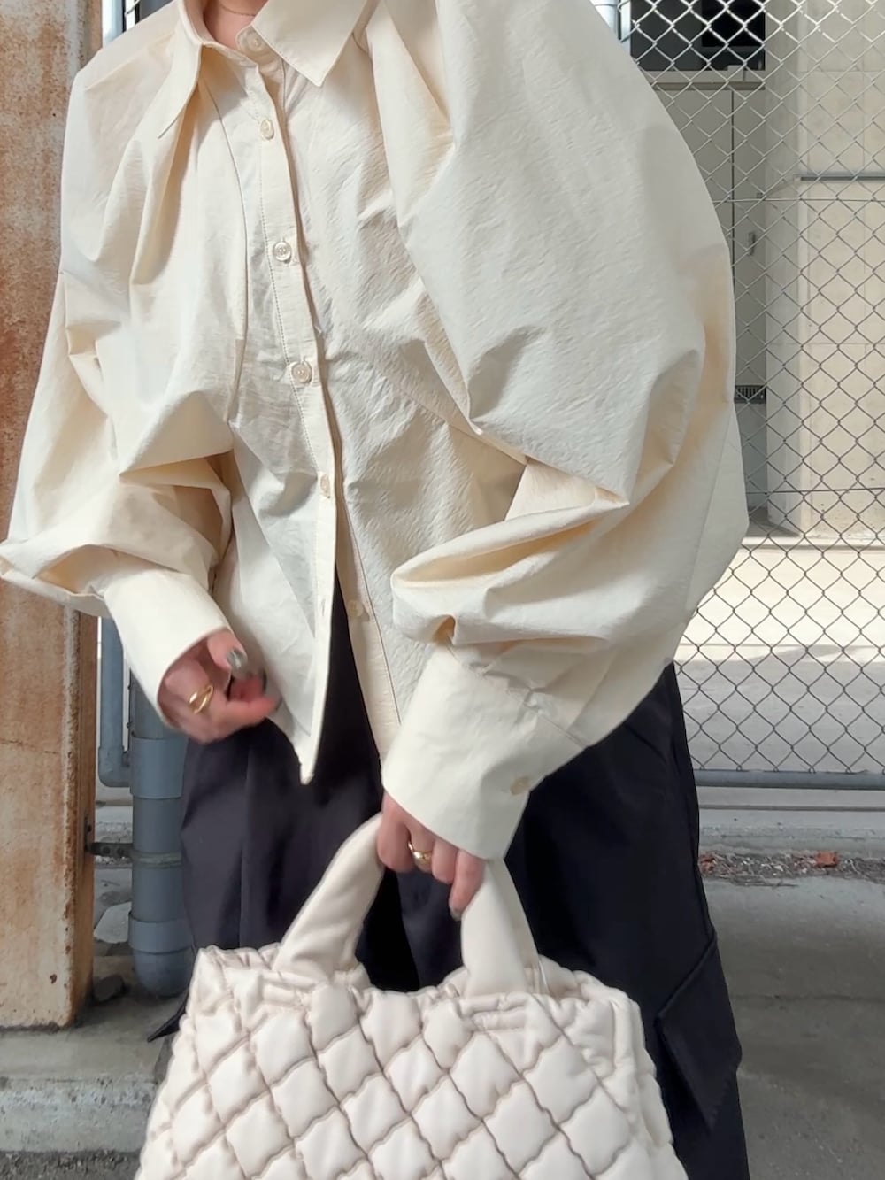 ベージュ系のシャツ/ブラウス、ブラック系のその他パンツ、ホワイト系のハンドバッグを着用したレディースの秋コーディネートの4枚目の写真