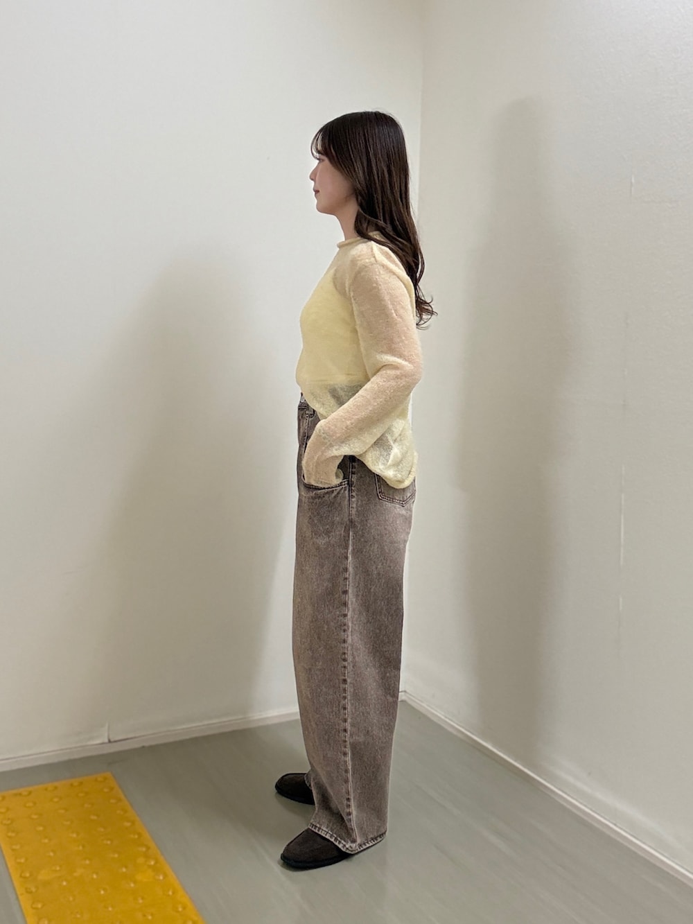 ブラウン系のデニムパンツ、ブラウン系のローファーを着用したレディースの冬コーディネートの2枚目の写真