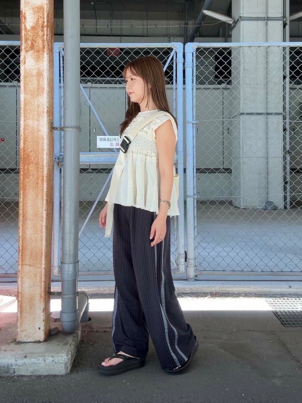 ブルー系のその他パンツ、ホワイト系のショルダーバッグ、ホワイト系のTシャツ/カットソーを着用したレディースの夏コーディネートの2枚目の写真