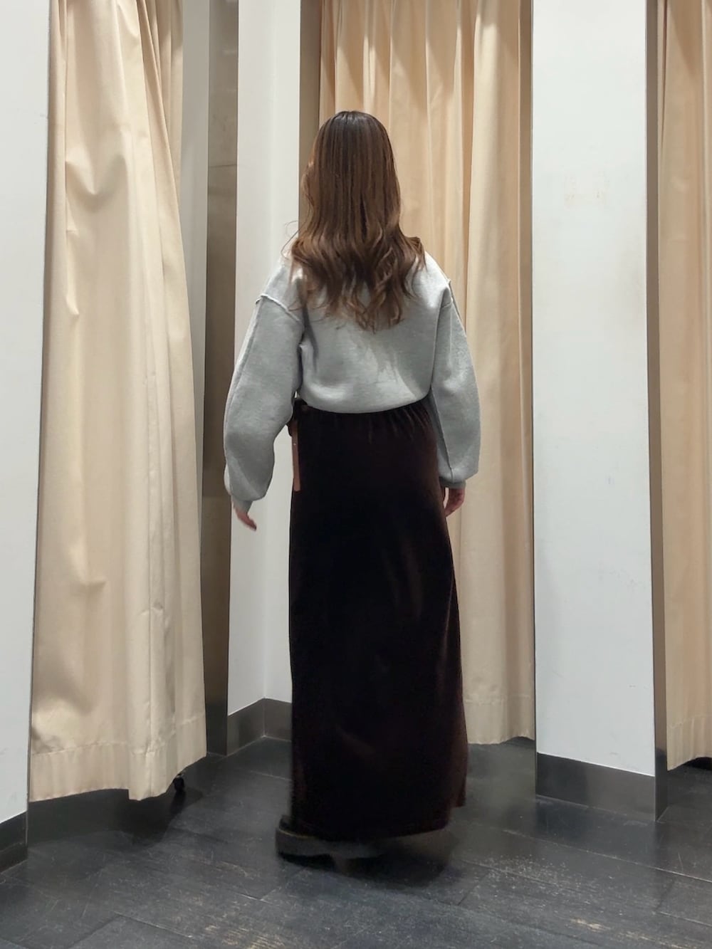 グリーン系のニット/セーター、ブラウン系のスカート、ブラウン系のベルトを着用したレディースの冬コーディネートの3枚目の写真