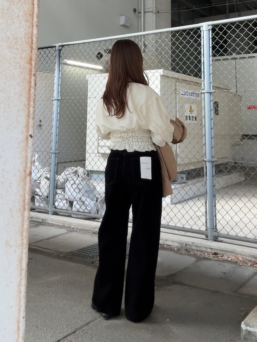 ベージュ系のステンカラーコート、ホワイト系のシャツ/ブラウス、ブラック系のデニムパンツを着用したレディースの冬コーディネートの5枚目の写真