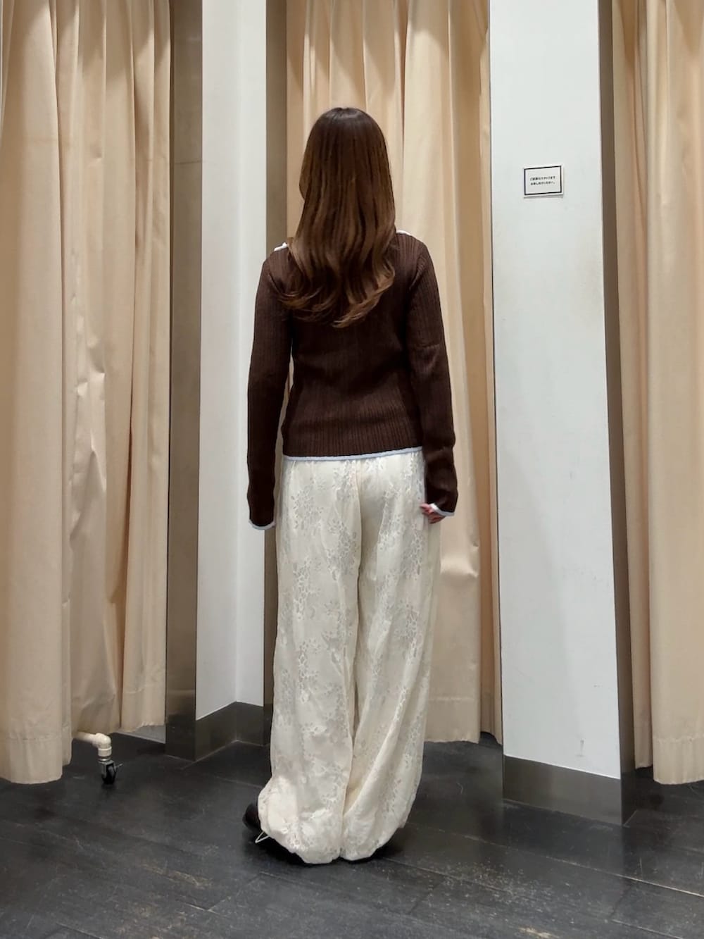 ブラウン系のニット/セーター、ホワイト系のその他パンツ、ブラック系のサンダルを着用したレディースの冬コーディネートの3枚目の写真