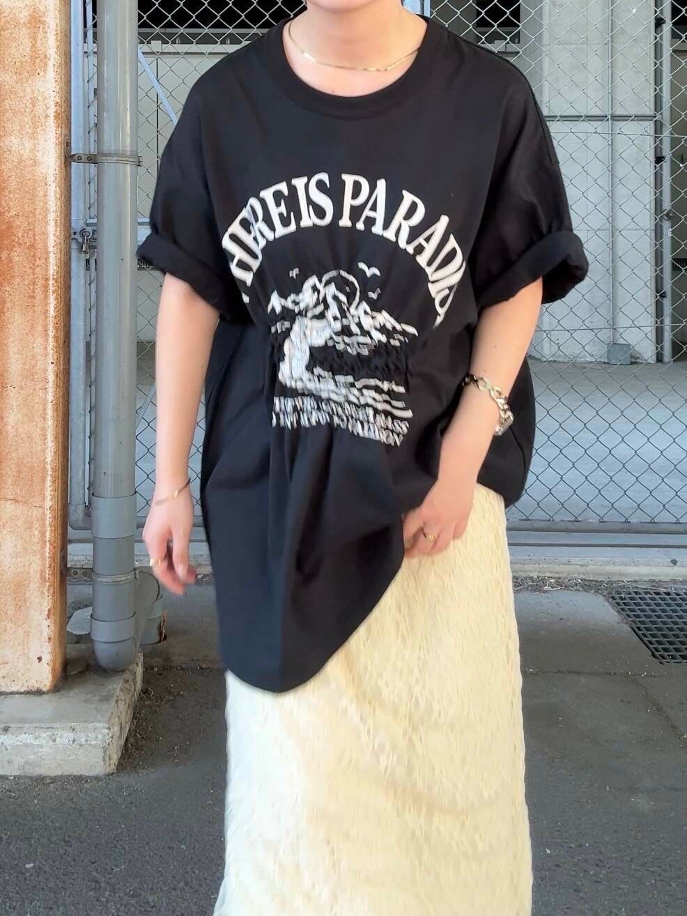 ブラック系のTシャツ/カットソー、ホワイト系のスカート、ブラウン系のヘアゴムを着用したレディースの夏コーディネートの4枚目の写真