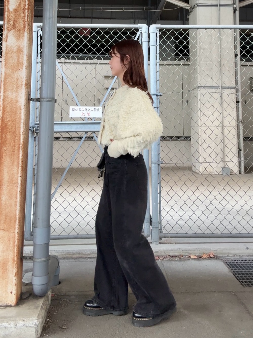 ホワイト系のカーディガン/ボレロ、ブラック系のデニムパンツ、ブラック系のショルダーバッグを着用したレディースの冬コーディネートの3枚目の写真