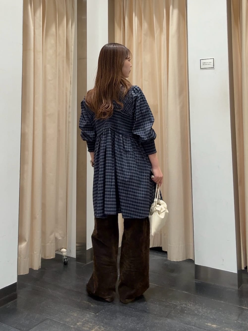 ブルー系のワンピース、ホワイト系のショルダーバッグ、ブラウン系のデニムパンツを着用したレディースの春コーディネートの3枚目の写真