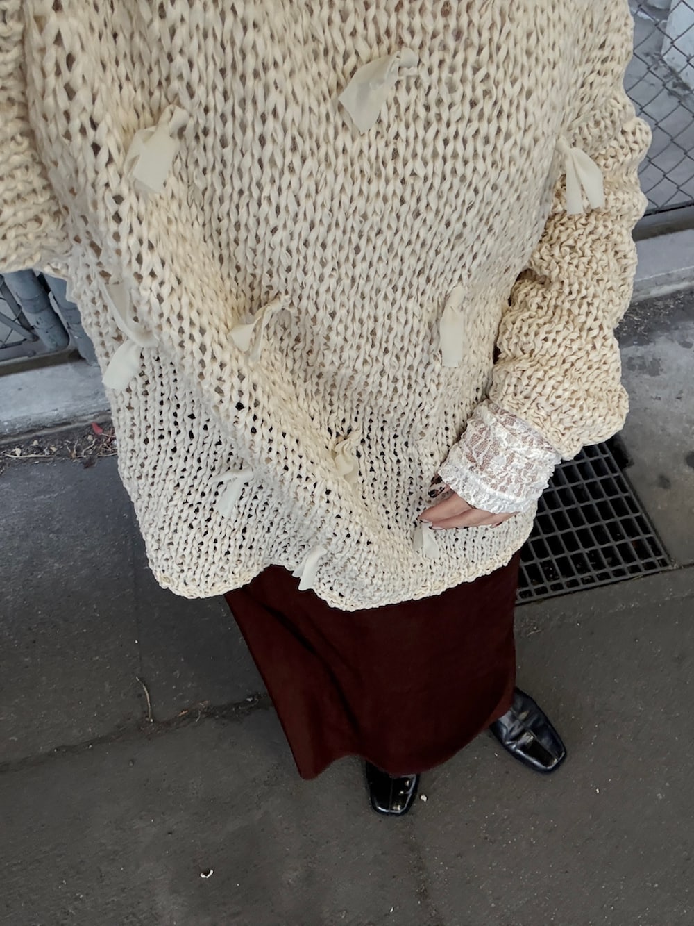 ホワイト系のニット/セーター、ホワイト系のTシャツ/カットソー、ブラウン系のスカートを着用したレディースの冬コーディネートの4枚目の写真