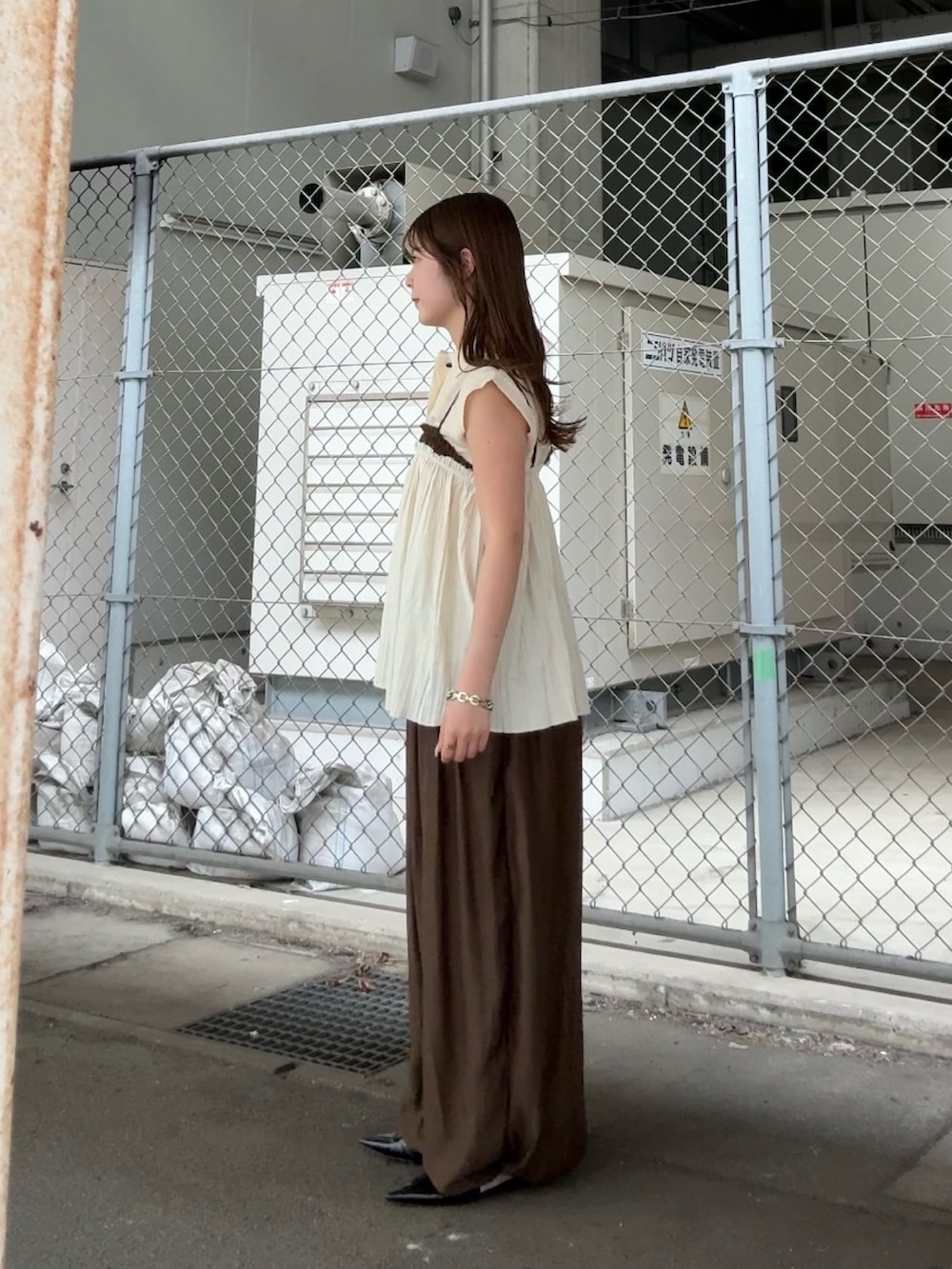 ホワイト系のニット/セーター、ホワイト系のその他トップス、ブラウン系のその他パンツを着用したレディースの春コーディネートの2枚目の写真