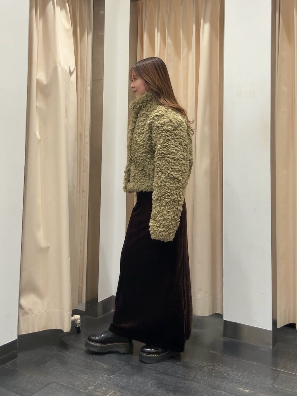 グリーン系のその他アウター、ブラウン系のスカートを着用したレディースの冬コーディネートの2枚目の写真