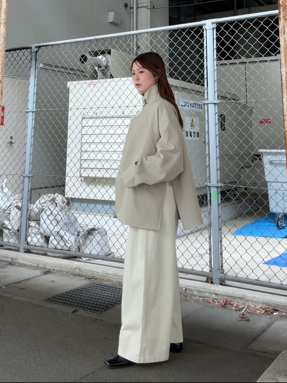 ベージュ系のその他アウター、ホワイト系のニット/セーター、ホワイト系のTシャツ/カットソーを着用したレディースの春コーディネートの2枚目の写真