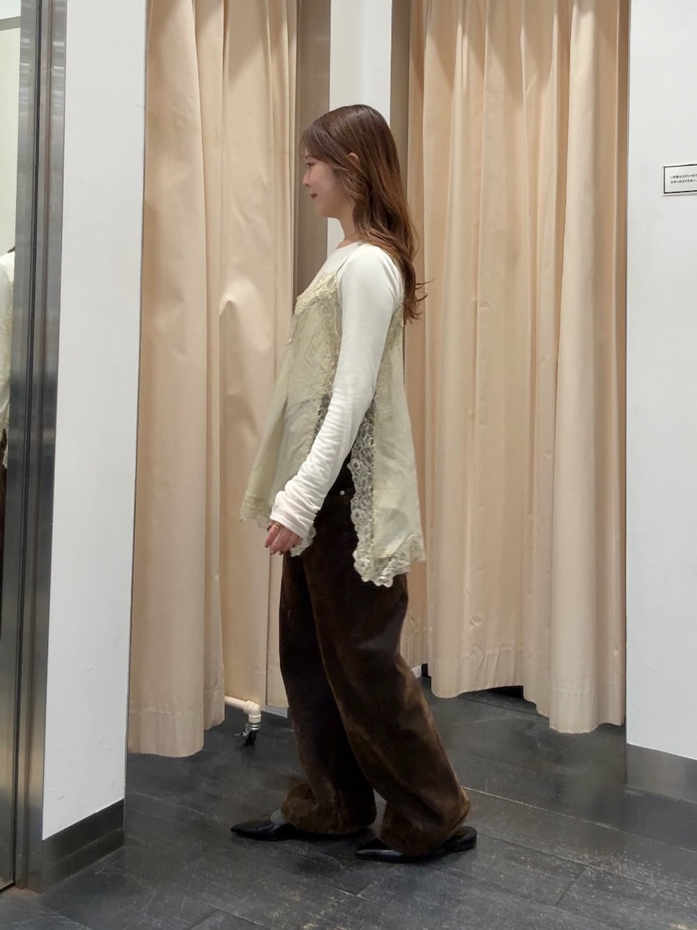 ホワイト系のTシャツ/カットソー、ベージュ系のキャミソール、ブラウン系のデニムパンツを着用したレディースの冬コーディネートの2枚目の写真