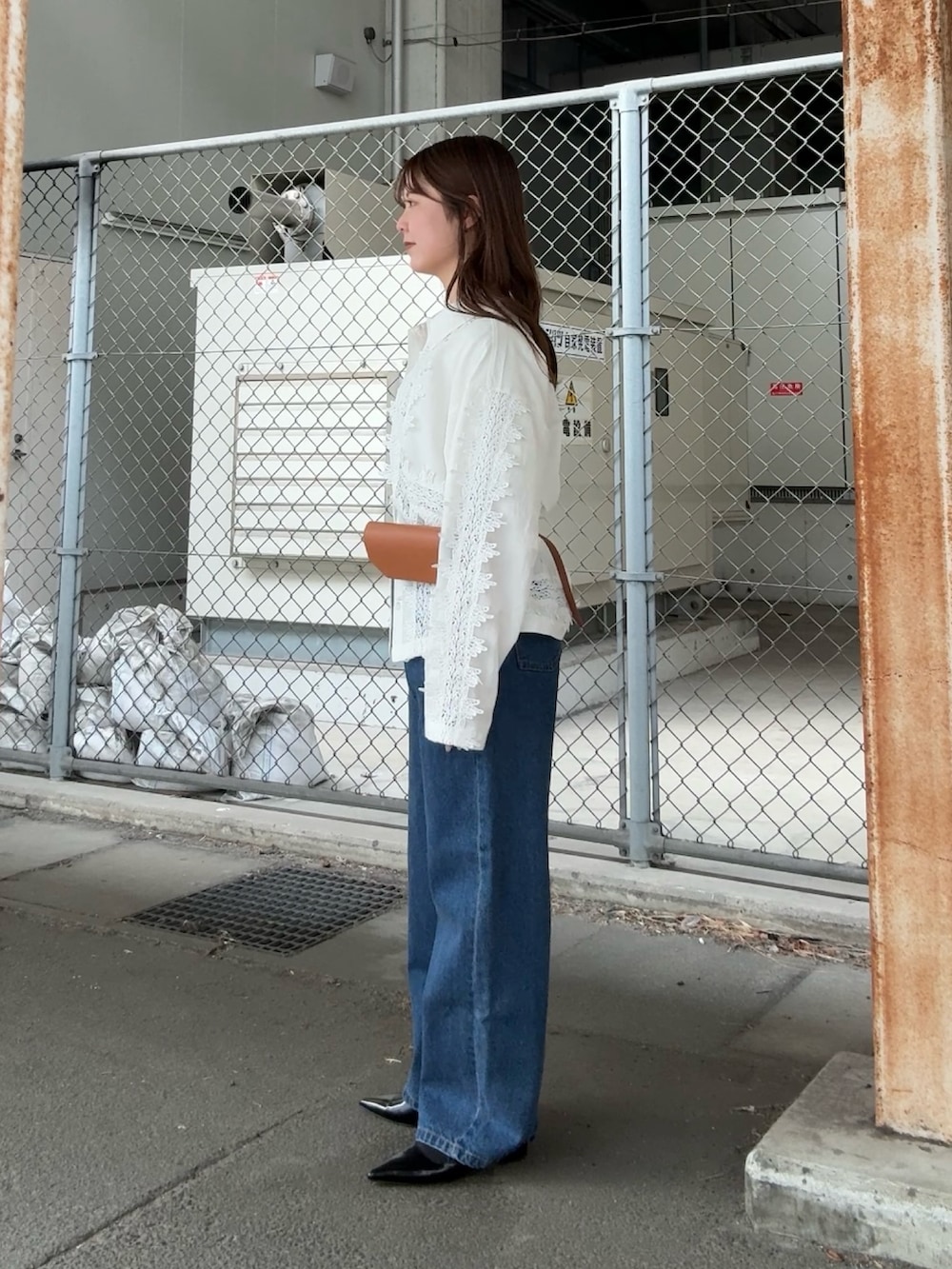 ホワイト系のシャツ/ブラウス、ブルー系のデニムパンツ、イエロー系のボディバッグ/ウエストポーチを着用したレディースの冬コーディネートの2枚目の写真