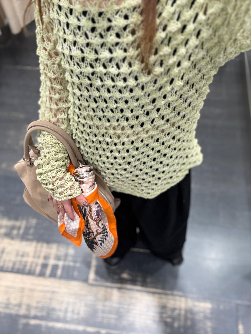 グリーン系のニット/セーター、ブラック系のその他パンツ、ベージュ系のボストンバッグを着用したレディースの春コーディネートの4枚目の写真