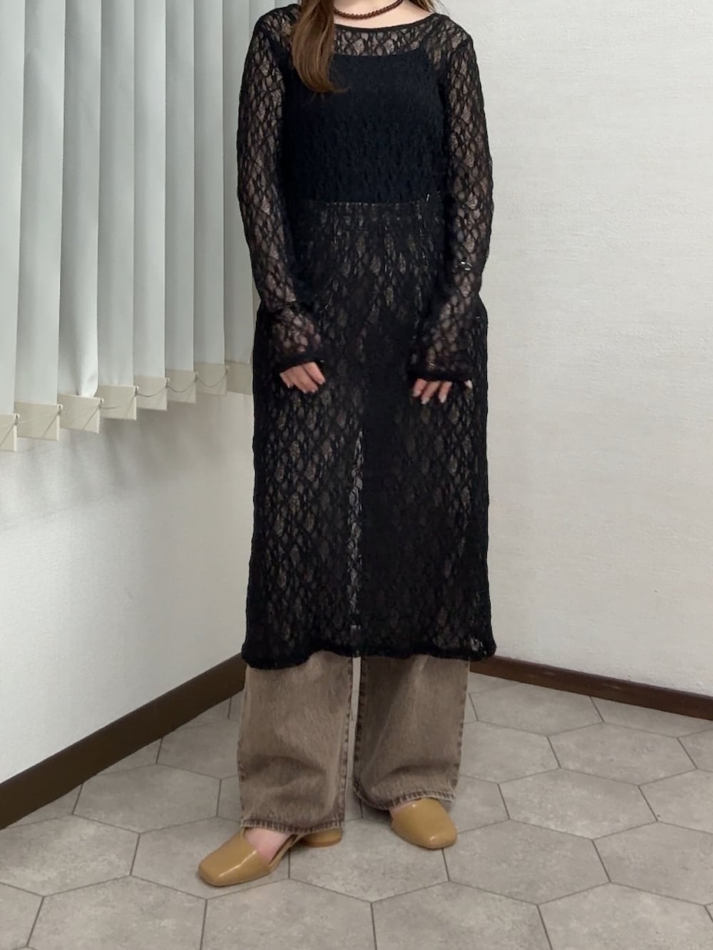 ブラック系のワンピース、ブラウン系のデニムパンツ、イエロー系のパンプスを着用したレディースの春コーディネートの4枚目の写真