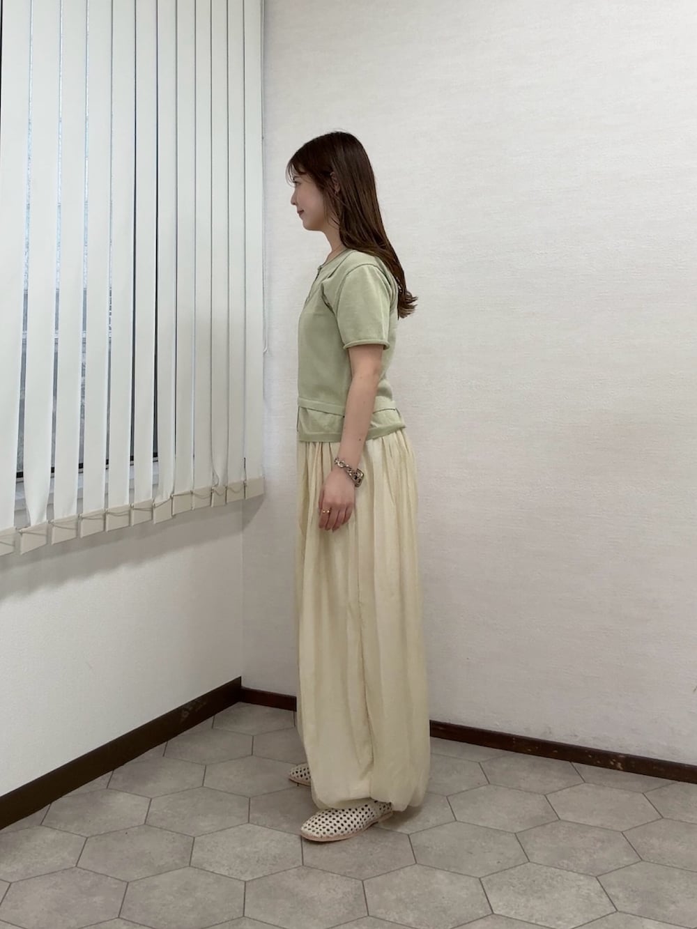 ベージュ系のカーディガン/ボレロ、ホワイト系のその他パンツ、ホワイト系のサンダルを着用したレディースの春コーディネートの2枚目の写真
