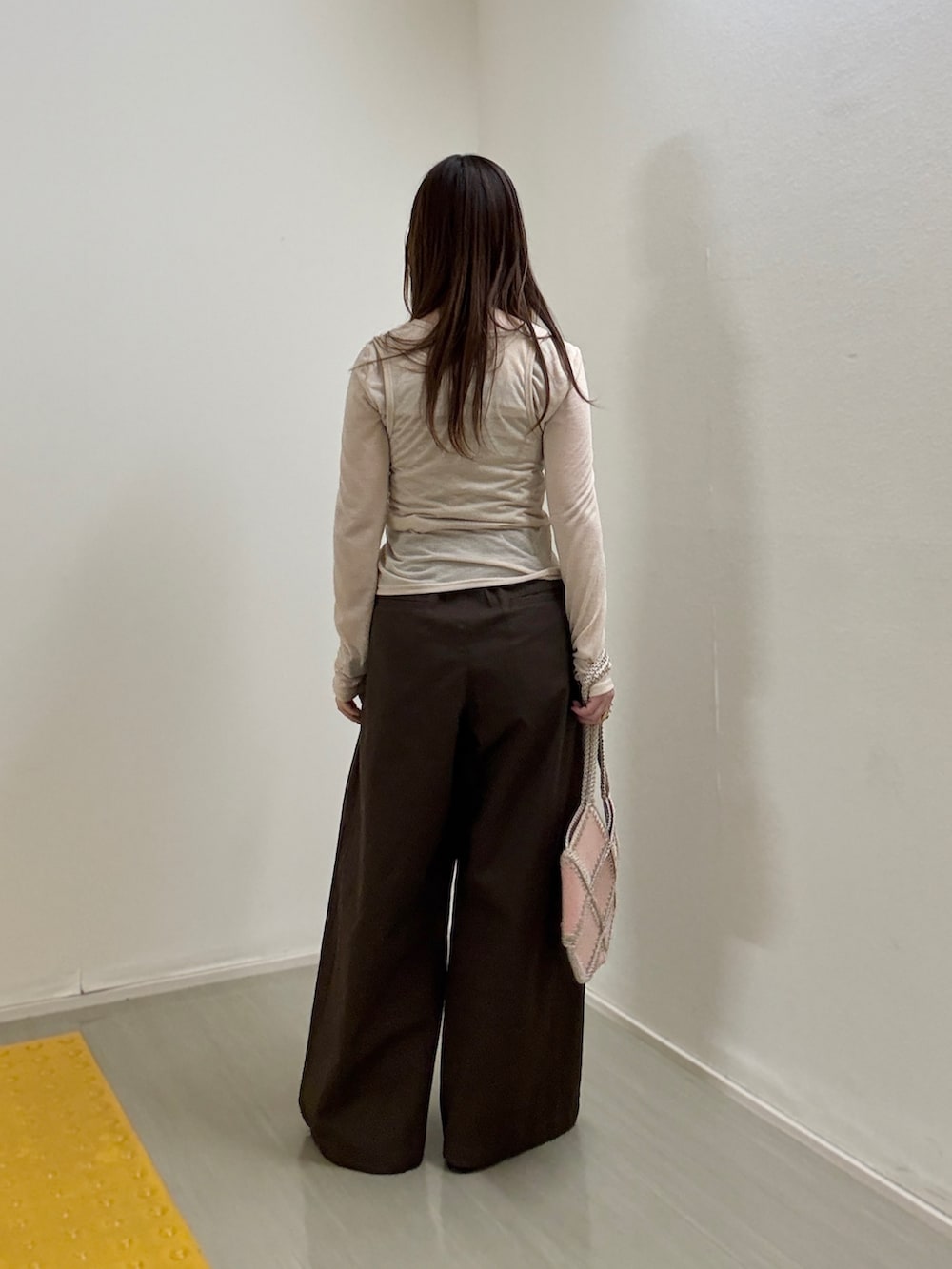 ピンク系のショルダーバッグ、ベージュ系のTシャツ/カットソー、ブラウン系のその他パンツを着用したレディースの春コーディネートの3枚目の写真