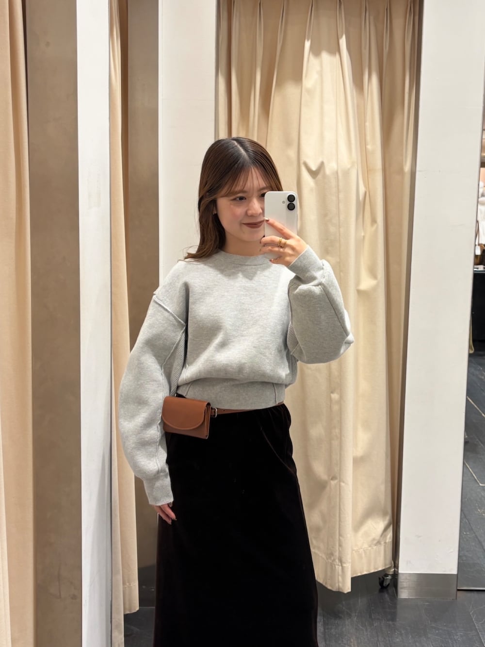 グリーン系のニット/セーター、ブラウン系のスカート、ブラウン系のベルトを着用したレディースの冬コーディネートの4枚目の写真