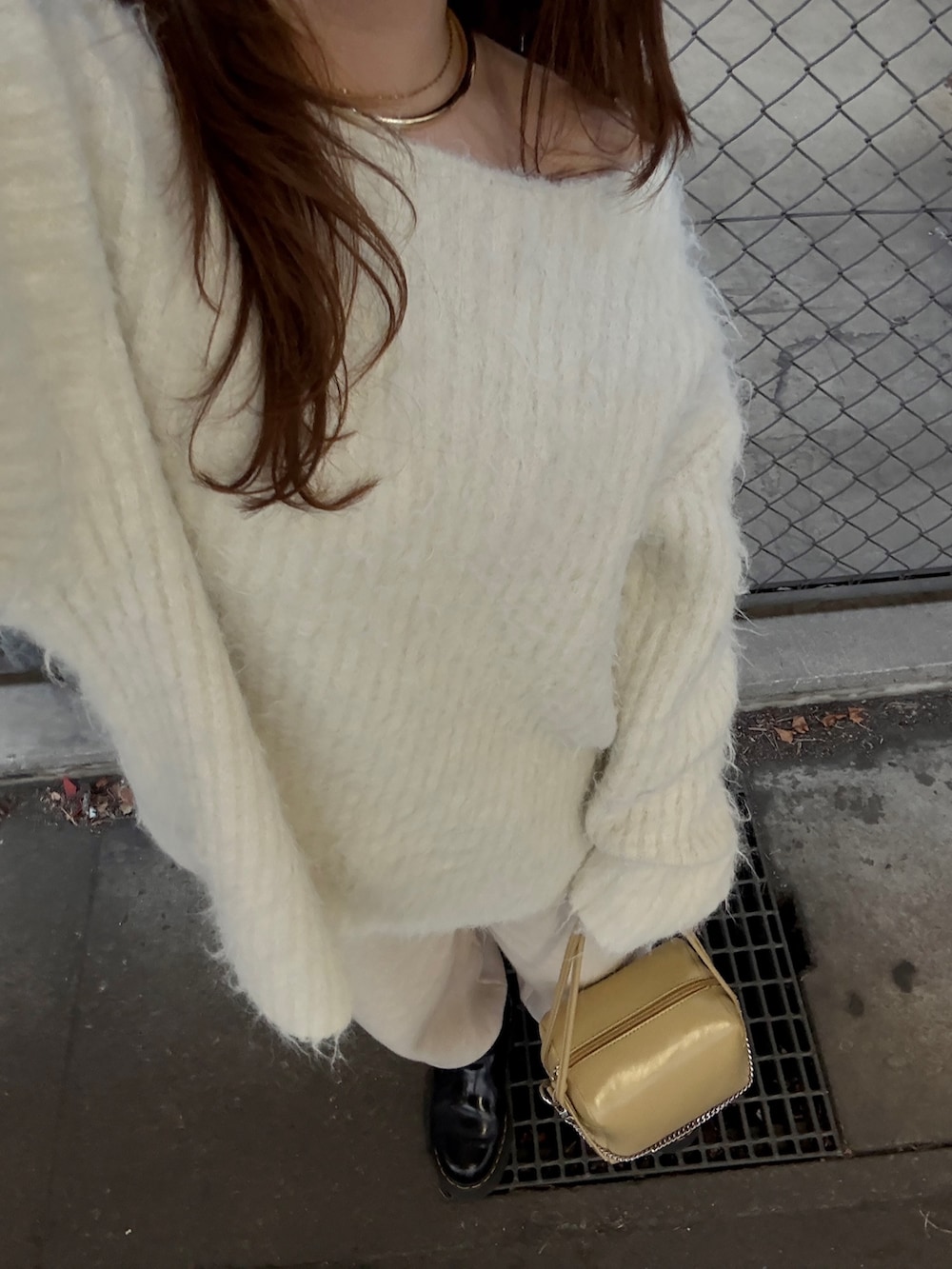 ホワイト系のニット/セーター、ベージュ系のその他パンツ、ベージュ系のショルダーバッグを着用したレディースの冬コーディネートの4枚目の写真