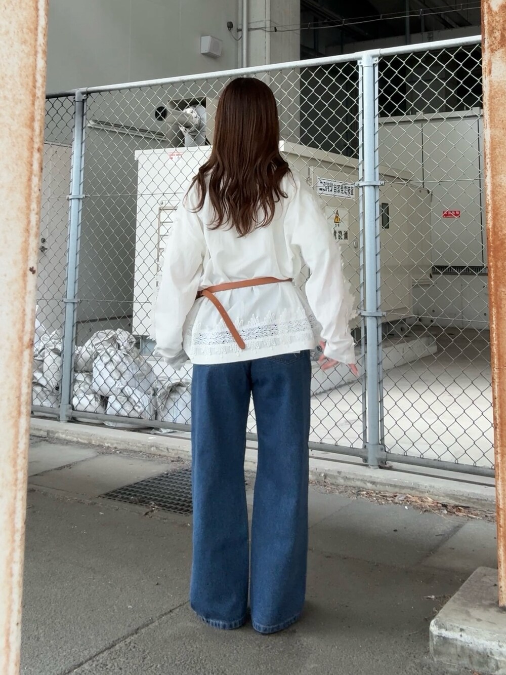 ホワイト系のシャツ/ブラウス、ブルー系のデニムパンツ、イエロー系のボディバッグ/ウエストポーチを着用したレディースの冬コーディネートの3枚目の写真