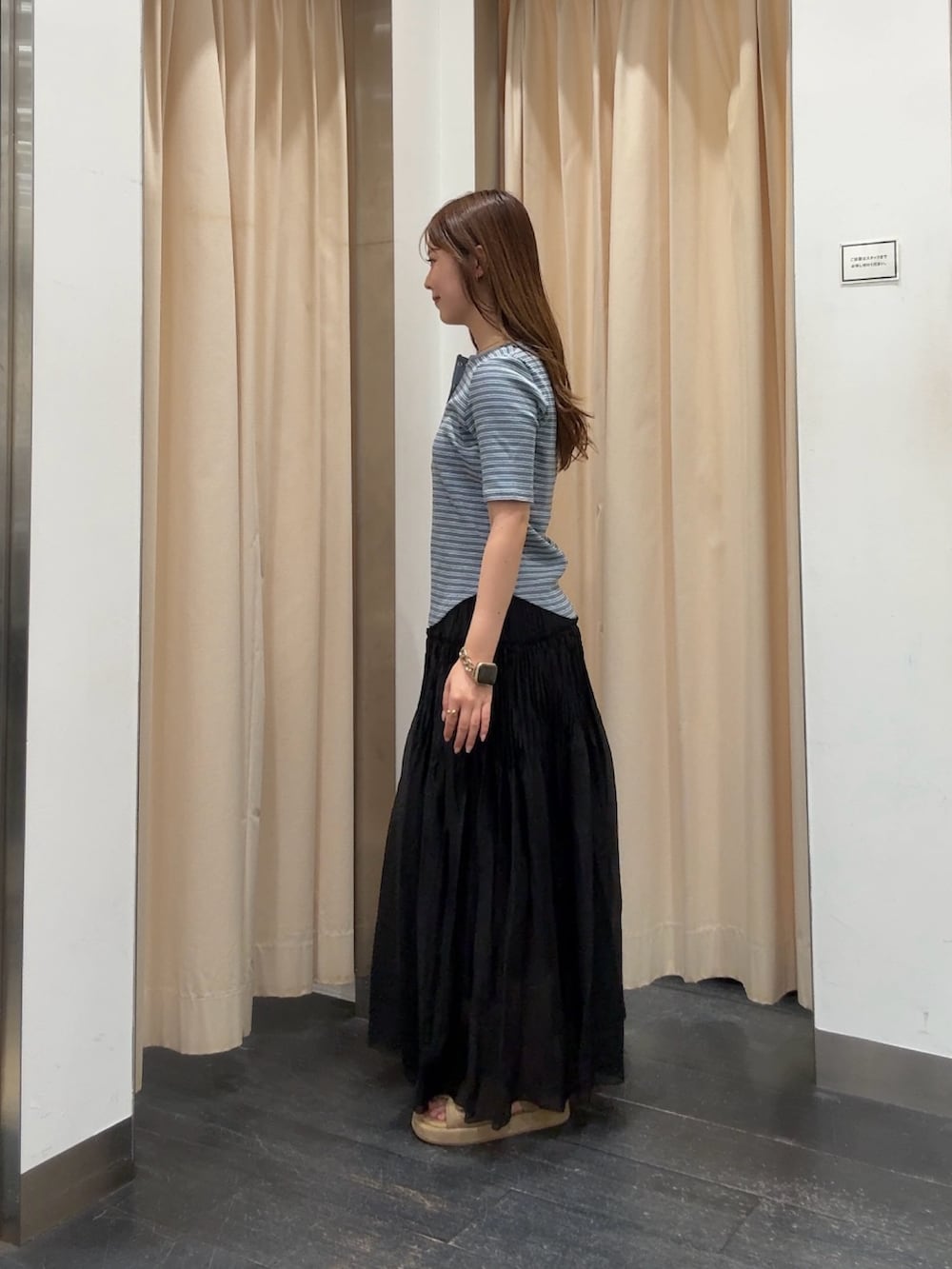 ブルー系のTシャツ/カットソー、ブラック系のスカート、ベージュ系のサンダルを着用したレディースの夏コーディネートの2枚目の写真