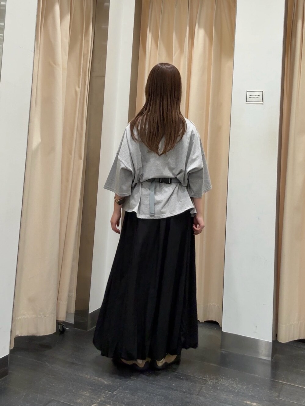 グレー系のTシャツ/カットソー、ブラック系のスカート、ベージュ系のスニーカーを着用したレディースの春コーディネートの3枚目の写真